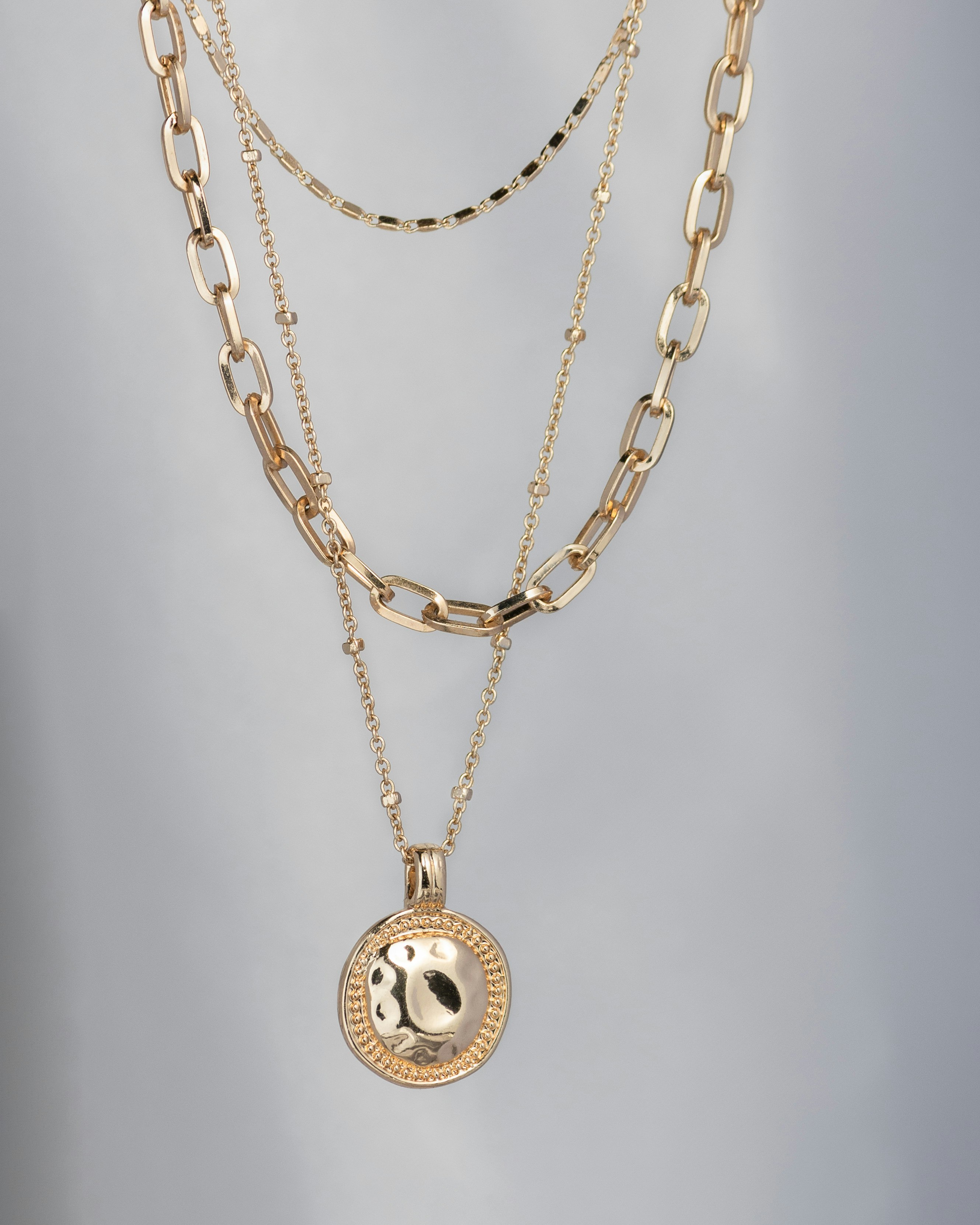 Layered fine gold necklaces at Saleh Jewelers in Lawrenceville, Georgia